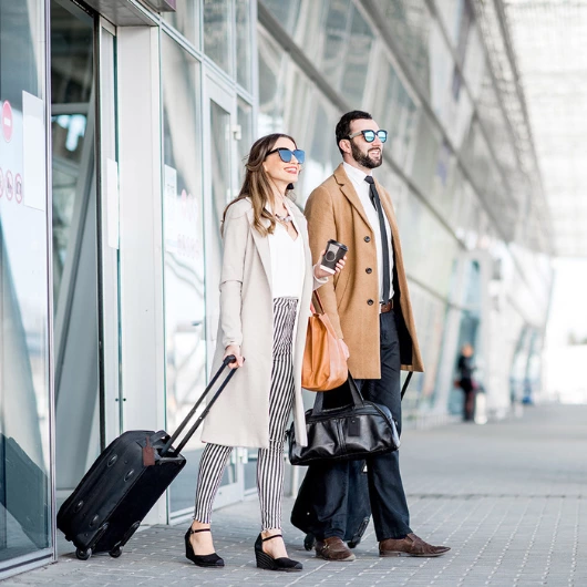A couple at the airport going towards their ride at the airport