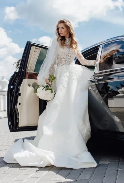 A bride getting out of a black luxury fleet
