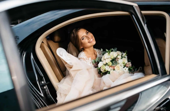 A bride sitting in a luxury wedding limo